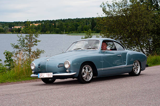 VOLKSWAGEN KARMANN-GHIA from 1957 Sater, Sweden - July 23, 2010: Two car enthusiast driving an old car  VOLKSWAGEN KARMANN-GHIA from 1957,  in a classic car cavalcade on small public roads around the small town Sater in Sweden karman stock pictures, royalty-free photos & images