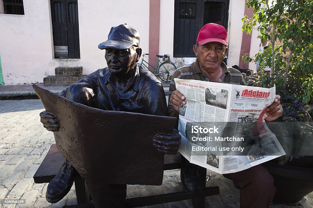 Uomo e la scultura di leggere quotidiani a Cuba - Foto stock royalty-free di Ambientazione esterna