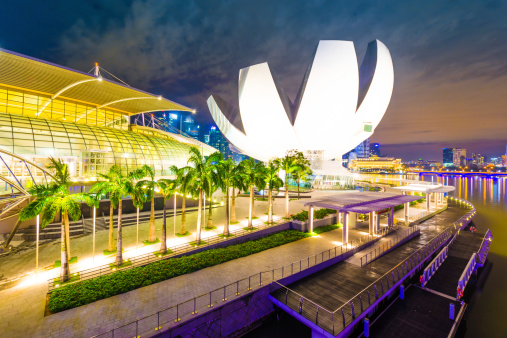 Singapore City, Singapore - November 3, 2012: A view of the ArtScience Museum at Marina Bay Sands, Singapore. It become a famous tourist attractions in Singapore. Some people are at the waterfront area.