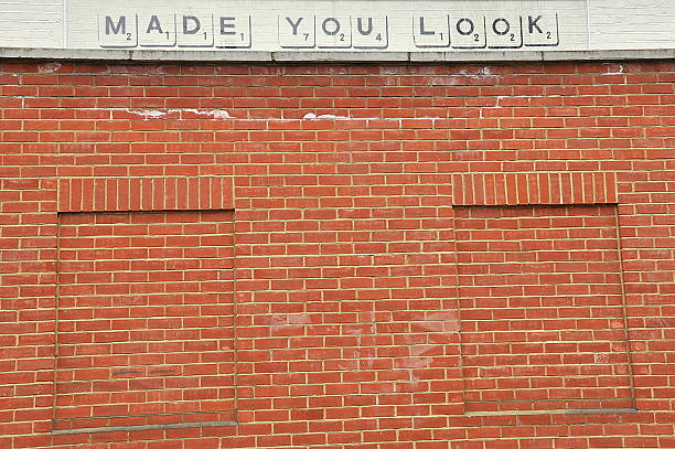 Banksy Graffiti In Nottinghill Nottinghill, UK - March 31, 2013: Banksy Graffiti  "Made You Look" on a brick wall in Nottinghill banksy stock pictures, royalty-free photos & images