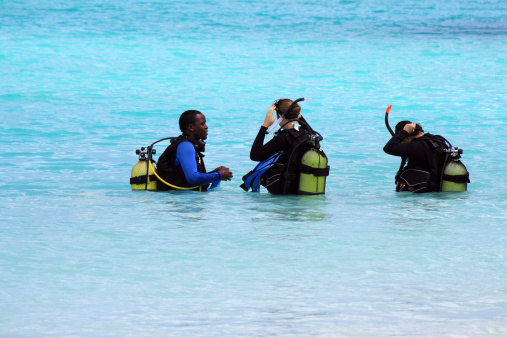 Zanzibar, Tanzania - October 18, 2010: A professional diver teaches two women how to dive in the crystal waters of Nungwi.