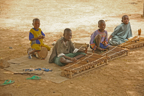 Banjul, The Gambia- March the 28, 2008: four boys siting on the ground in front of their wooden xylophones