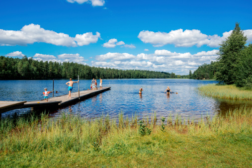 Norrkoping, Sweden - August 4, 2013:  People enjoying a sunny day at lake Sorsjon. Going to a lake for a swim is a typical leisure activity in Sweden at summertime.