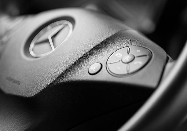 Ankara, Turkey-September 23,2012: Inside of Mercedes C180 AMG. Close up black and white photograph of steering wheel with mercedes logo and other control buttons.