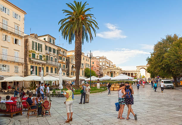 View to the Kapodistriou street with cafe tables and tourists Kerkyra, Greece - September 16, 2013: View to the Kapodistriou street into the city historic center with cafe tables and tourists. corfu holiday palace stock pictures, royalty-free photos & images