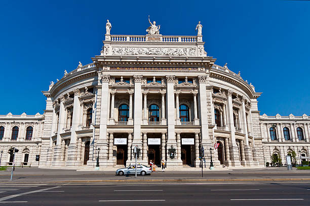 Burgtheater in Vienna. Vienna, Austria - June 19, 2013: The Burgtheater (Hofburg Theater) is the Austrian National Theatre. It is one of the most important German language theatres in the world and was created in 1741 as part of the Hofburg complex.  Wide angle view. Two theater workers are selling tickets outside. burgtheater vienna stock pictures, royalty-free photos & images