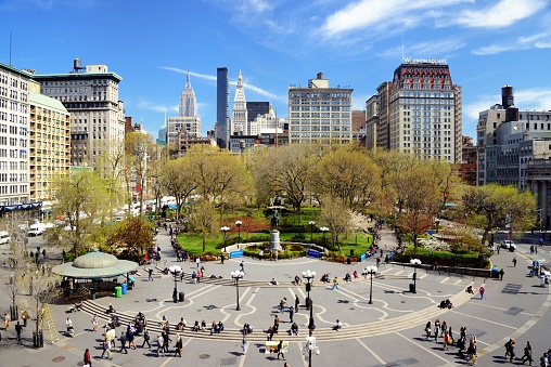 New York City, USA - April 17, 2013: People relax in Union Square. The Commissioners' Plan of 1811 created such an awkward angle at the location that a square was preferred over the perceived complications of erecting buildings.