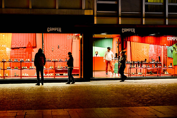 Paris, France  - December 26, 2012: Camper Shoe Store at night, Paris. People walking nearby, looking at window display