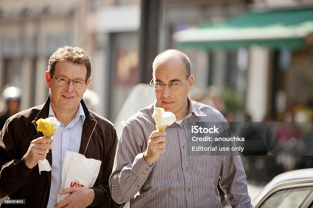 Dos hombres maduros a pie, comer helado, Milán - Foto de stock de Adulto libre de derechos