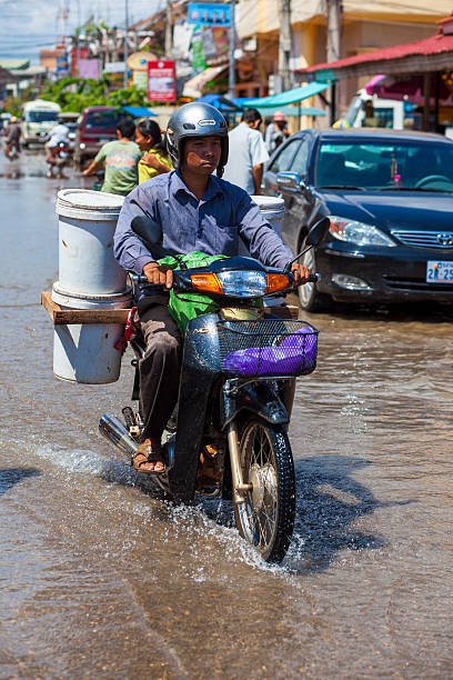 남자 드라이브 통해 floodwaters, 시엠레아프, 캄보디아 - flood people asia cambodia 뉴스 사진 이미지