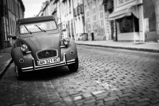Beaune, France - August 13, 2013: A Citroen 2CV, the French car myth, was parked in a beautiful street in Beaune, Burgundy, giving the scene an old times mood.