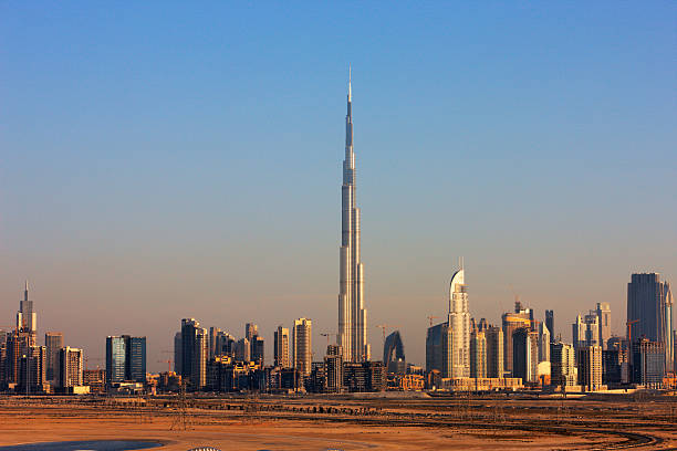 Dubai, United Arab Emirates - November 7, 2023: A picture of the Burj Khalifa towering over the nearby Downtown Dubai buildings and the blue waters of the Burj Khalifa Lake.