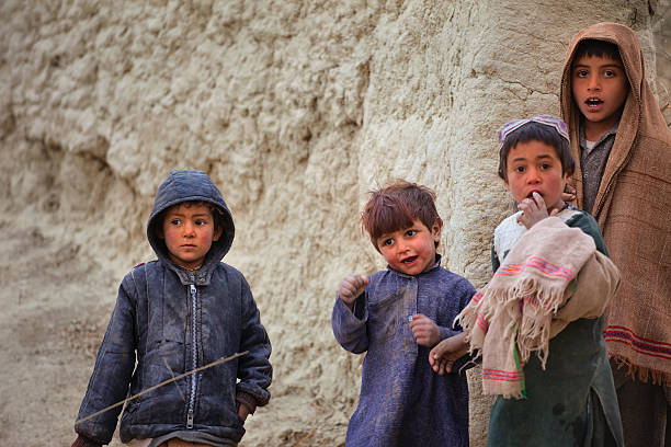 afgano bambini guardando un pattuglia - kandahar foto e immagini stock