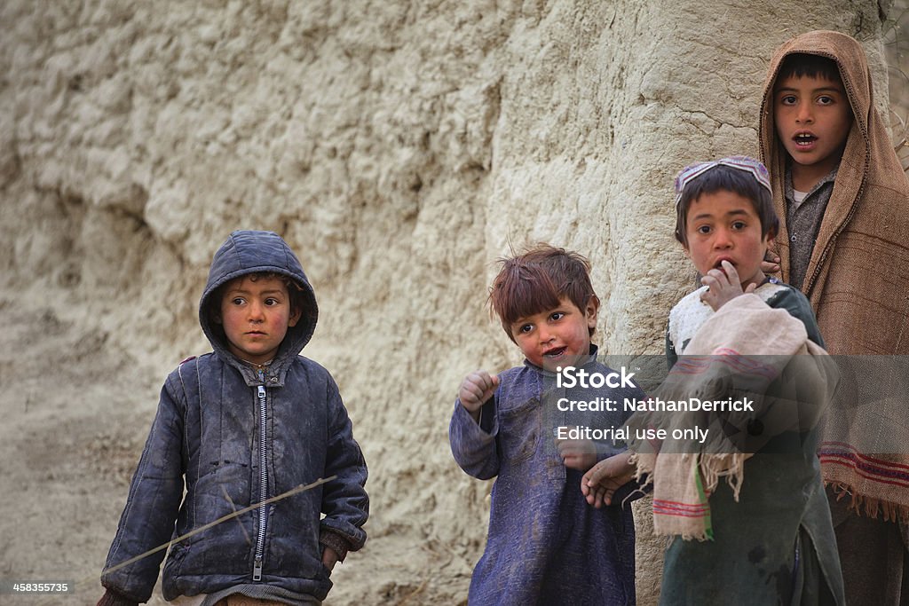 Afghan Kids watching a patrol Kandahar, Afghanistan - January 10, 2011: A group of Afghan children watch a patrol walk through their village Afghanistan Stock Photo