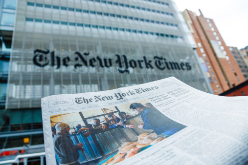 New York City, USA - May 9, 2013: A The New York Times newspaper in front of The New York Times company office building at 620 8th Avenue, Midtown Manhattan, New York City. It was completed in 2007 and it is owned by The New York Times Company and Forest City Ratner Companies.