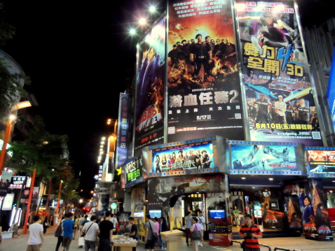 Taipei, Taiwan aa August 20, 2012: Movie theaters and movie billboards at Ximending.Visitors walk in the pedestrian zone of Ximending at night.