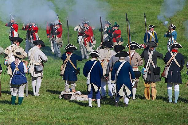 Fredonia, Wisconsin, USA, August 31, 2013: At the annual Pioneer Village encampment, American Revolution reenactors portraying British crown forces fire a musket volley at the American rebel line.