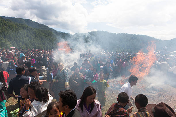 Village people jump through two burning haystacks at Thangbi festival stock photo