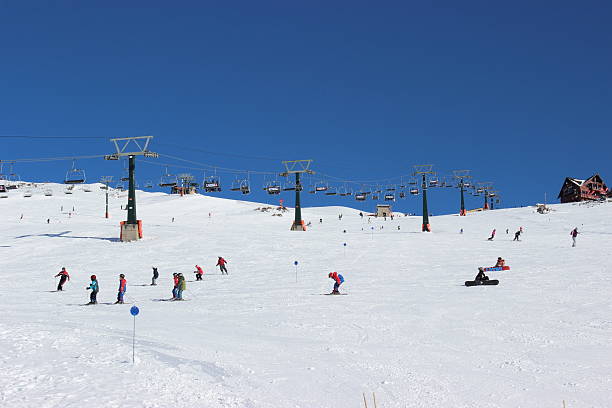 People skiing CERRO CATEDRAL - Lynch Refuge at backgrounf stock photo