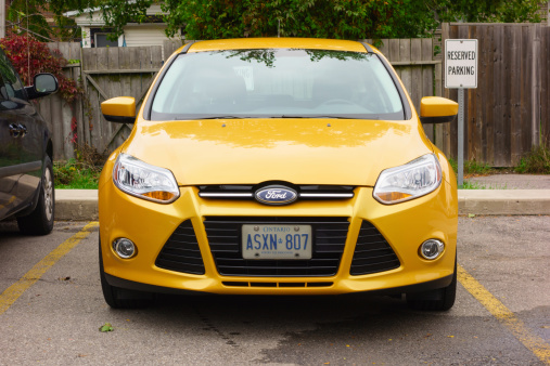 Hamilton, Canada - October 5, 2013: Yellow colored, third generation Ford Focus hatchback parked in a parking lot.
