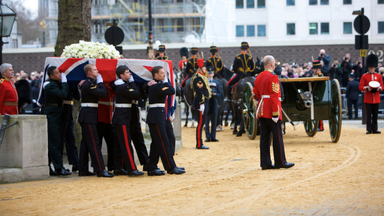 London, United Kingdom - April, 17th 2013: The coffin of Baroness Thatcher is carried out of St Clement Danes Church by a Tri-Service Bearer Party ready to be placed onto a gun carriage of The King's Troop Royal Horse Artillery, before continuing it's journey to the funeral service at Saint Paul's Cathedral.