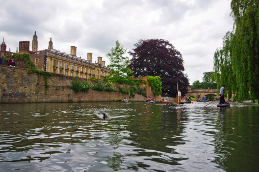 Cambridge, United Kingdom - June 16, 2013: Lazy Sunday afternoon on the River Cam in Cambridge, England, tourists on punts with tourists looking on.