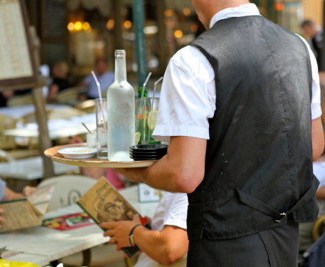 Aix en Provence, France - August 4, 2013: The French cafA culture always has waiters serving you at the table. In the town of Aix en Provence many tourists sit outisde at the many cafAs in the old town.