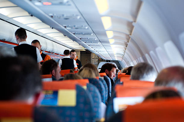 Passengers and flight attendents on a plane stock photo