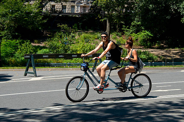 tandem bicyclists, west drive, central park, nowy jork - editorial shadow new york city manhattan zdjęcia i obrazy z banku zdjęć