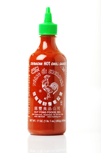 Colorado Springs, Colorado, USA - March 27, 2011: A bottle of Huy Fong\'s Rooster brand Thai hot sauce against white background. Huy Fong\'s Sriracha hot chili sauce is An American\'s favorite hot sauce.