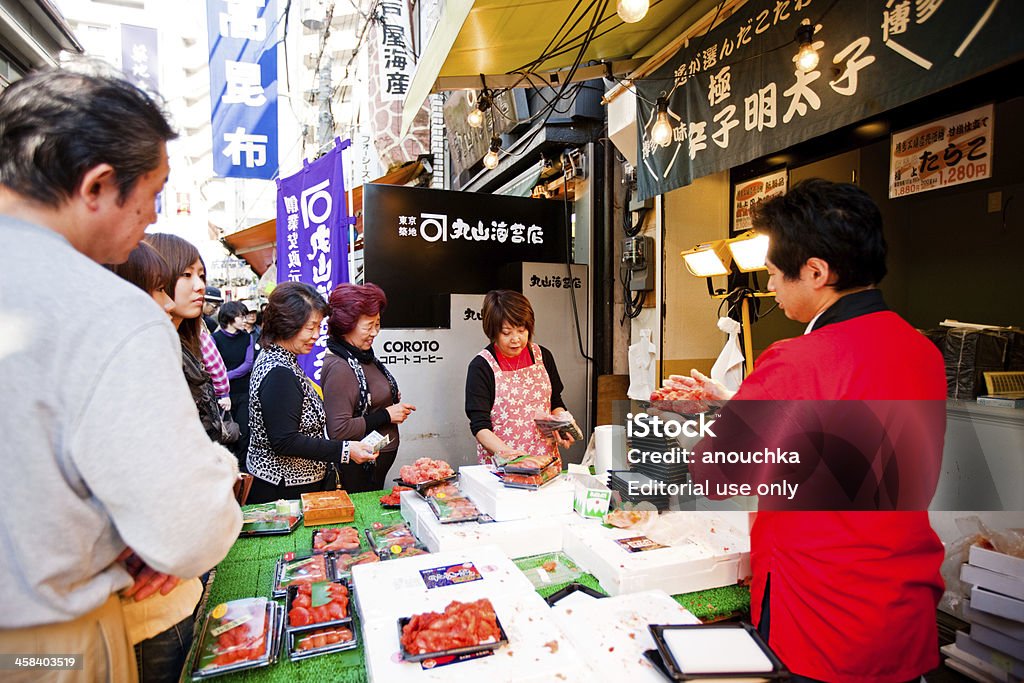 Fornecedores atendendo os clientes, o Mercado de Peixes de Tsukiji, Tóquio - Foto de stock de Adulto royalty-free