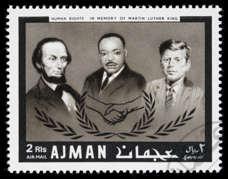 Sacramento, California, USA - December 24, 2008: A 1968 Ajman postage stamp with portraits of US human rights' leaders Abraham Lincoln, Martin Luther King, Jr, and John F Kennedy. The stamp is part of the \