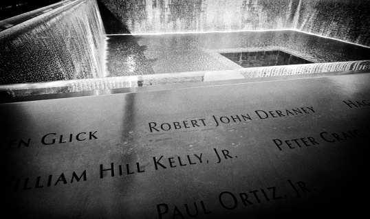 New York City, USA - August 27, 2013: Names of people inscribed at the North Reflecting Pool of the National September 11 Memorial at Ground Zero, Lower Manhattan.