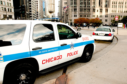 Сhicago, USA - October 28, 2013: Chicago police cars parked along Michigan avenue in downtown with people passing by early in the morning. 