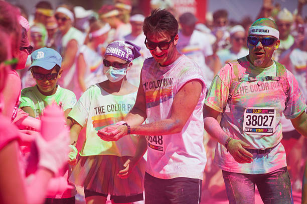 happy people at the Color Run in Cologne Cologne, Germany - July 21, 2013: competitors at a ColorRun in Cologne, Germany. Color Run is since a few years a world wide upcoming charity event with fun character. The competitors are sprayed with color powder. cologne germany stock pictures, royalty-free photos & images