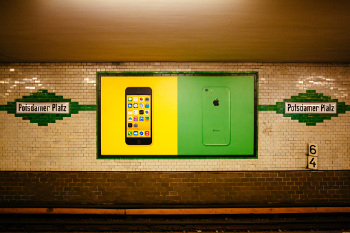 Berlin, Germany - November 14, 2013: a colorful large billboard promotes the new Apple iPhone 5 c in the underground of Berlin located in Potsdamer Platz.