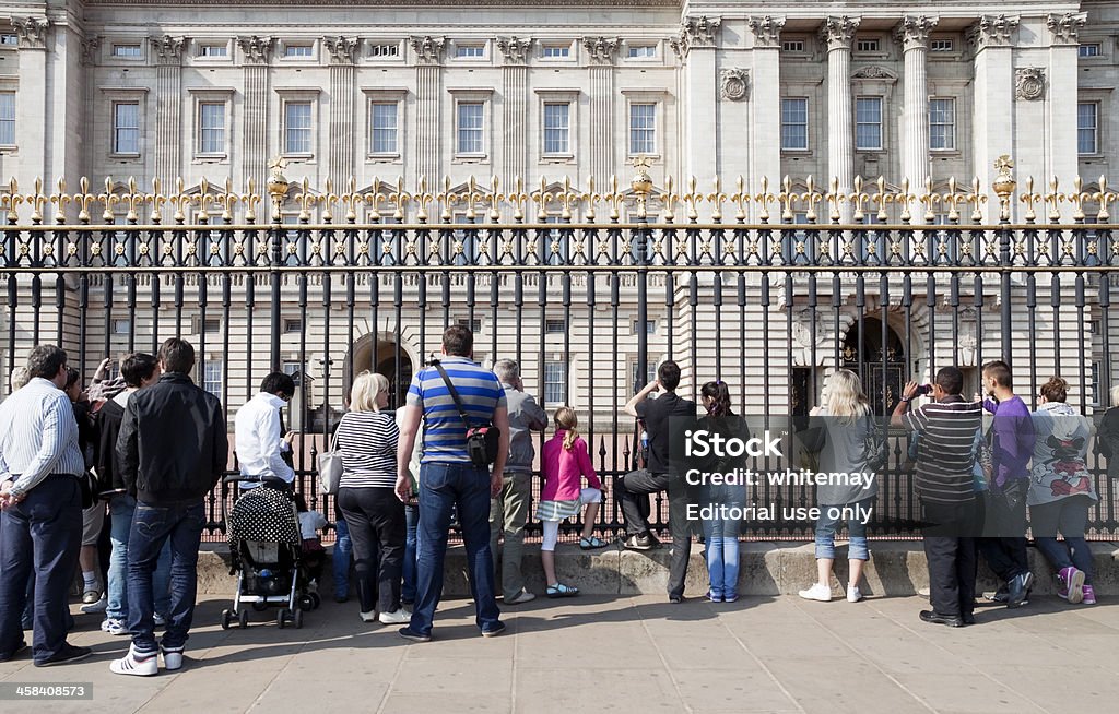 Tourists outside Buckingham Palace London, England - April 25, 2011: A row of tourists pressed up against the railings outside Buckingham Palace, London. The Palace is a place of intense international interest all year round, even when the Queen is not in residence and when there is no other activity such as the Changing of the Guard ceremony. Admiration Stock Photo