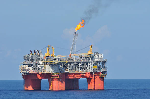 Off shore oil production platform with flare stock photo