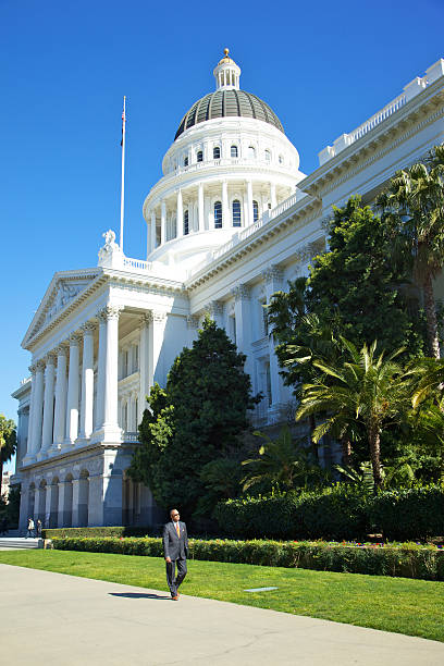 Sacramento, United States - February 10, 2011: California State House Capitol Sacramento senior adult businessman African American male in dress suit walking on the outside walk of the State complex