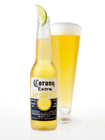 Calgary, Canada - April 5, 2011: Ice Cold Bottle and Glass of Corona Beer with a Lime shot in Studio on white with Natural Reflection, Corona is an Imported Beer from Mexico