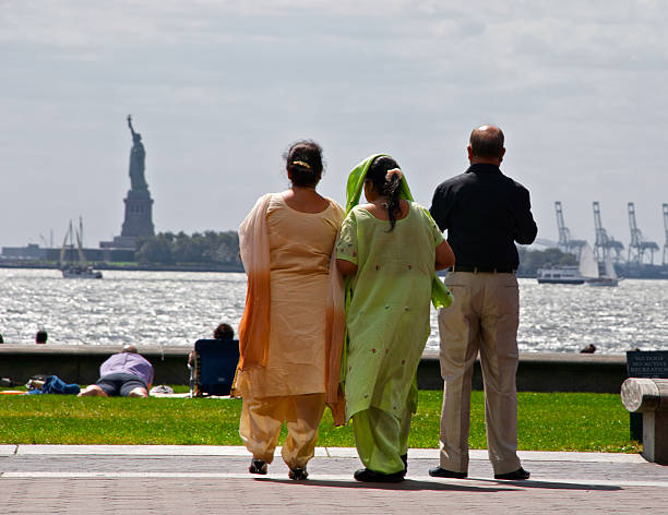 asiatico meridionale persone vista della statua della libertà a lower manhattan - editorial in a row national landmark famous place foto e immagini stock