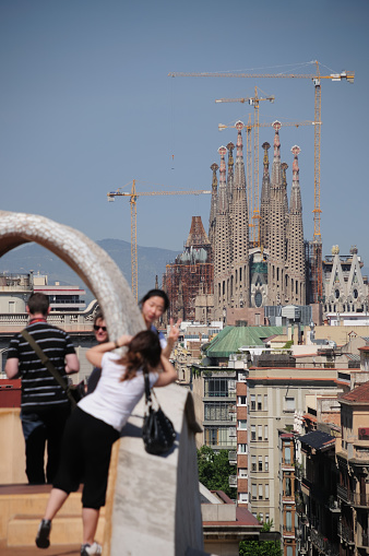 Barcelona, Spain - May 06, 2009:Tourists photographed with Antoni Gaudi\'s Sagrada Familia from La Pedrera Roof in Barcelona