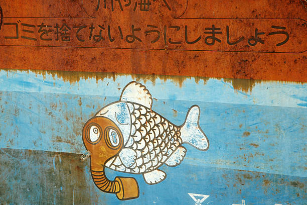 Osaka, Japan--7 April 2005: A rusting piece of sheet metal at river\\'s edge contains an illustration of a fish wearing an oxygen mask and a warning in katakana and Kanji that humans are responsible for the condition of the fish in the water.