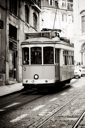 Lisbon, Portugal - May 19, 2011: A famous old-fashioned Lisbon tram (line 28) in front of the Se Cathedral (Lisbon Cathedral). Line 28 is often used by tourist as it drives by many of the tourist attraction in Lisbon.