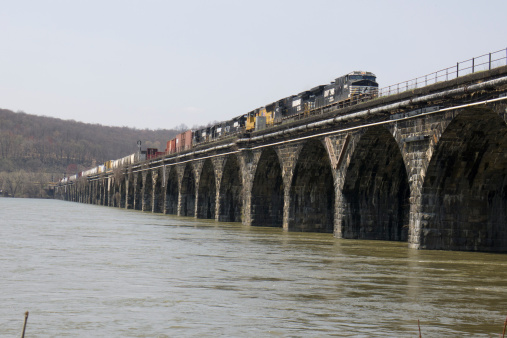 Harrisburg, Pennsylvania - April 15, 2011: A Norfolk Southern freight train crosses the Rockville Bridge, the longest stone masonry arch railroad viaduct in the world.