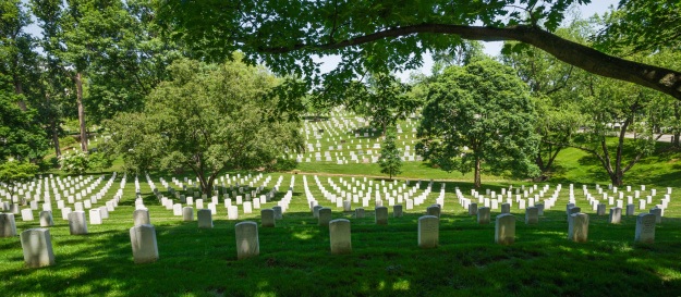 Arlington, Virginia, USA - May 20th. 2012: Multitude of tombstones shaded by the trees at Arlington National Cemetery, Virginia, USA.