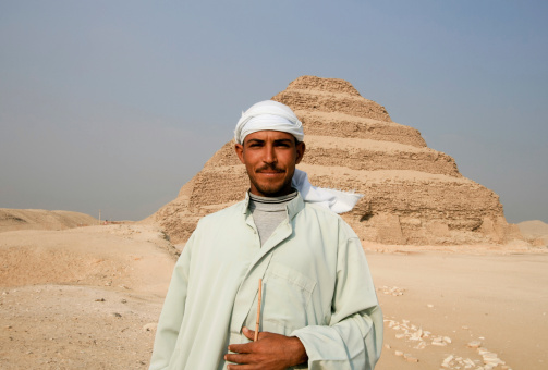 Saqqara, Egypt - November 15, 2007: A traditional Egyptian tribesman stands near the Step Pyramid in Saqqara, just outside Cairo, and looks at the camera. The man is local to the area.