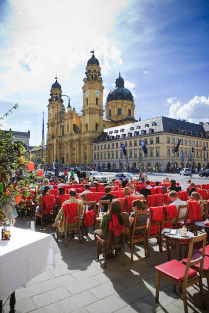 persone godendo il sole in café tambosi, odeonsplatz, monaco di baviera - chiesa dei frati teatini foto e immagini stock