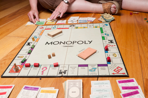 Phoenix, United States - June 18, 2011: Monopoly is a board game in which the players purchae property, build houses and hotels, and charge for other players who land on their property.  The winner is determined when one player has so much money and property that the other players are bankrupted.