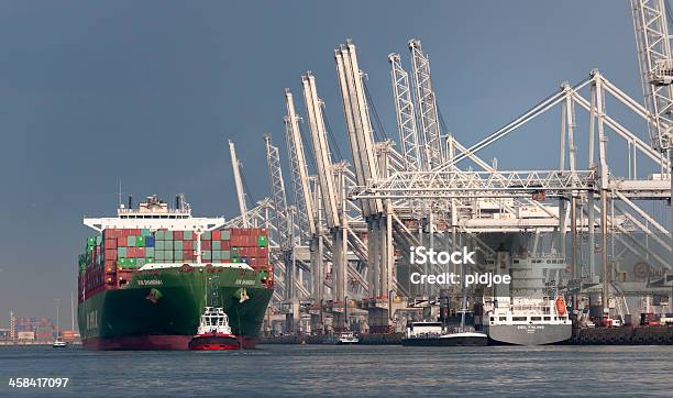 Tugboat Towing Cargo Container Ship In Commercial Dock Stock Photo - Download Image Now